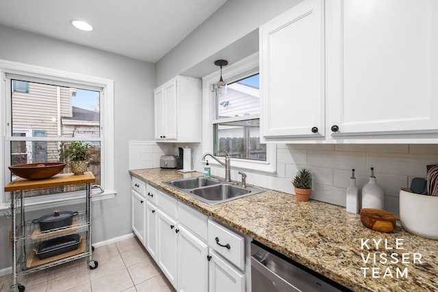 kitchen featuring light tile patterned floors, a sink, white cabinetry, baseboards, and backsplash