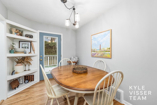 dining room with a chandelier and light wood finished floors