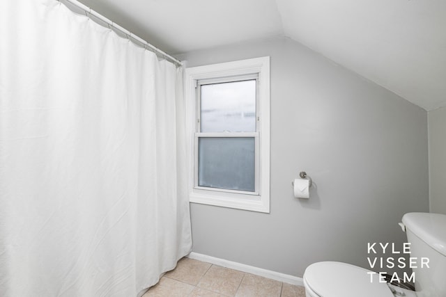 bathroom with toilet, baseboards, vaulted ceiling, and tile patterned floors