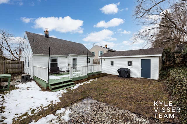 rear view of house with an outbuilding, a chimney, central AC, fence, and a deck