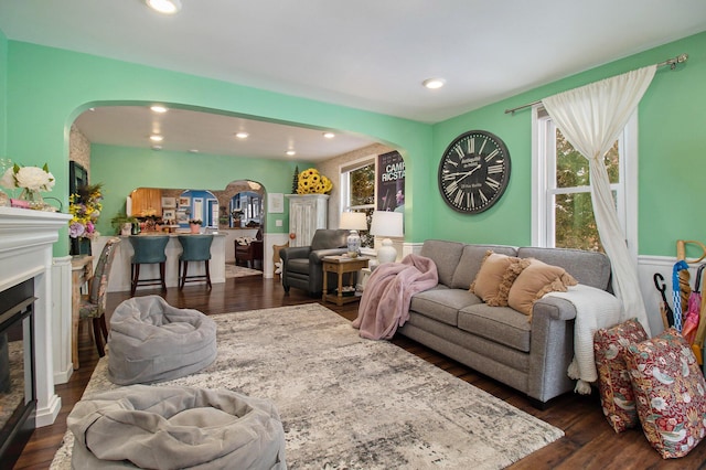 living room with a glass covered fireplace, dark wood finished floors, and recessed lighting