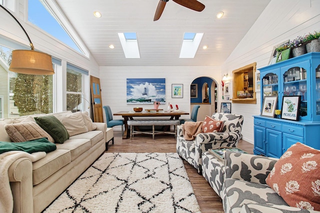 living area with arched walkways, a ceiling fan, wood finished floors, wood walls, and recessed lighting