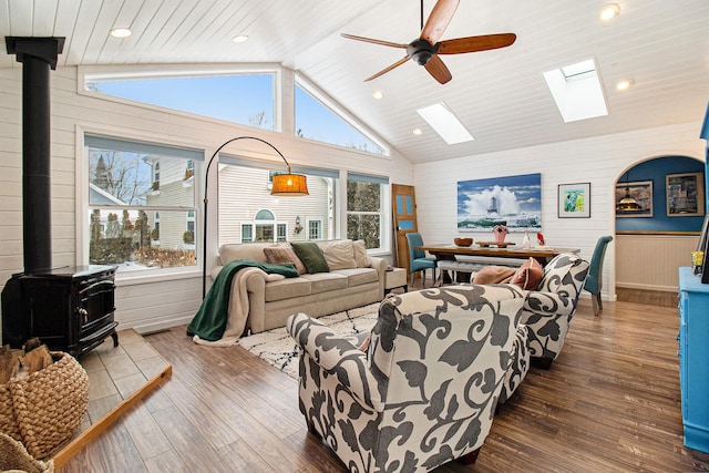 living room featuring a wood stove, a healthy amount of sunlight, and wood finished floors