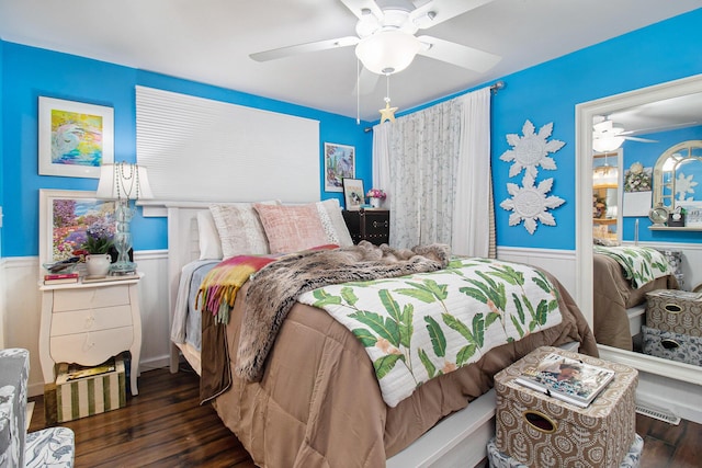 bedroom with a wainscoted wall, ceiling fan, and wood finished floors