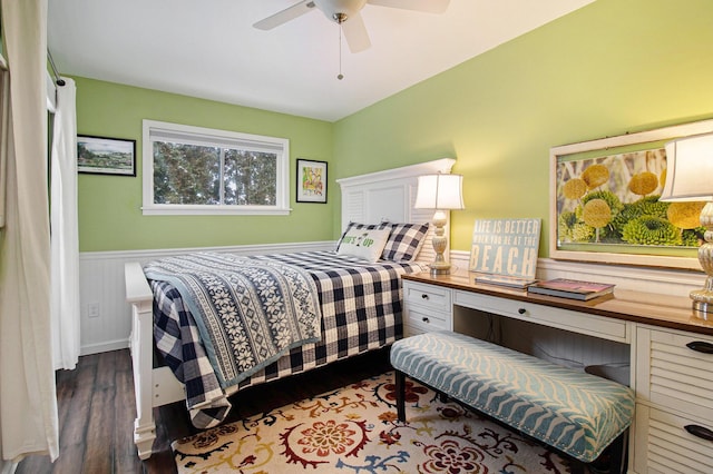 bedroom featuring a wainscoted wall and wood finished floors