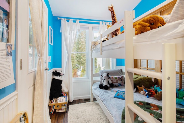 bedroom featuring multiple windows and wood finished floors