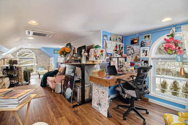 office area with vaulted ceiling, plenty of natural light, wood finished floors, and visible vents