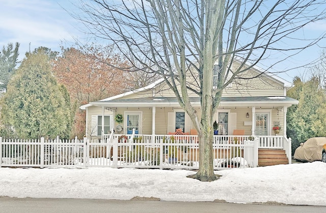 bungalow with covered porch and a fenced front yard