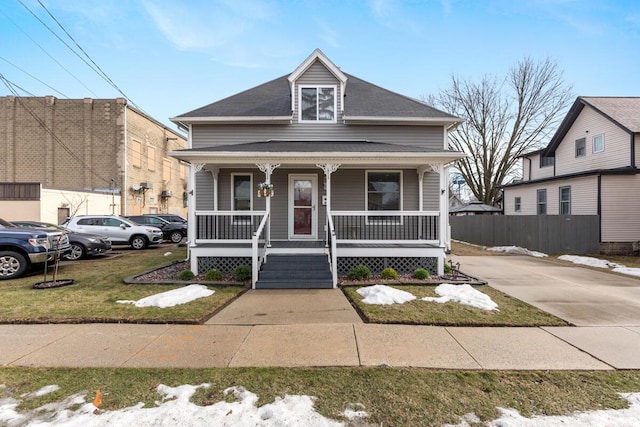 view of front of home with fence, a porch, and a front yard