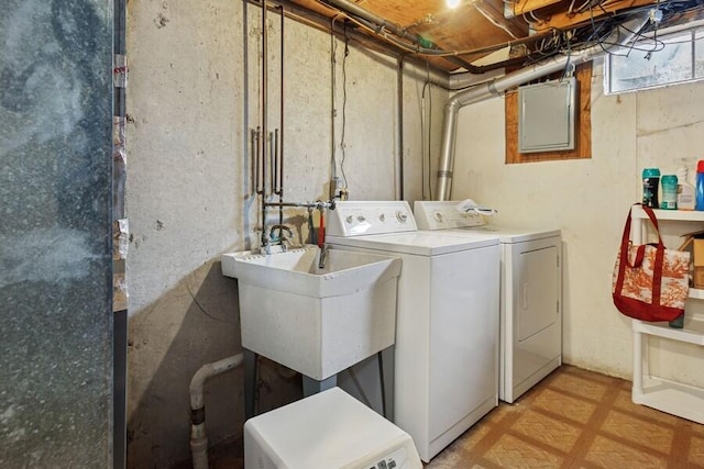 clothes washing area with laundry area, washing machine and dryer, and a sink