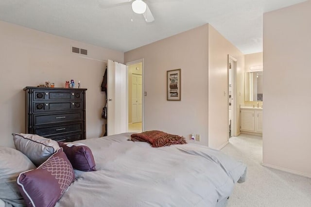 bedroom with connected bathroom, carpet flooring, a ceiling fan, visible vents, and baseboards