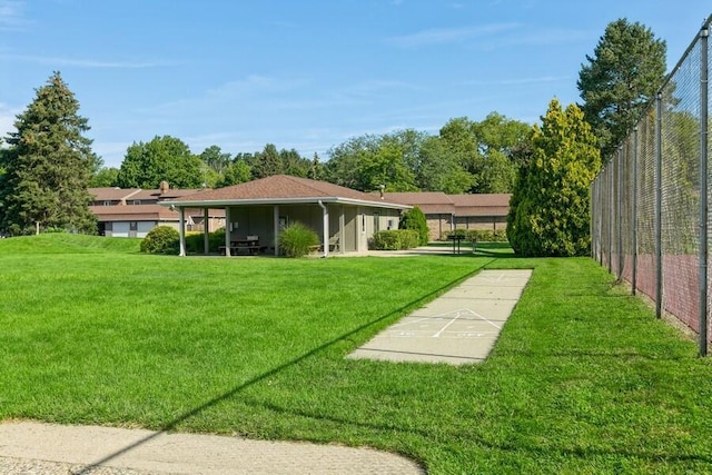 view of yard with shuffleboard and fence