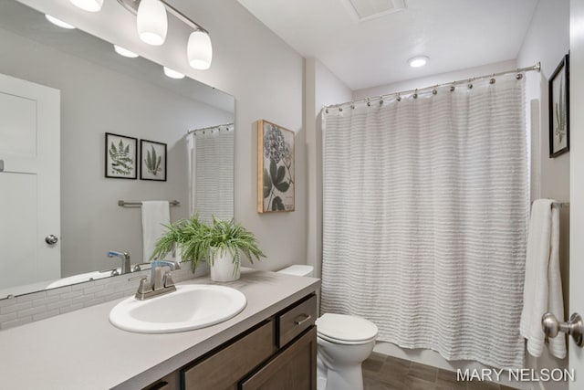 bathroom featuring vanity, toilet, and shower / bath combo with shower curtain