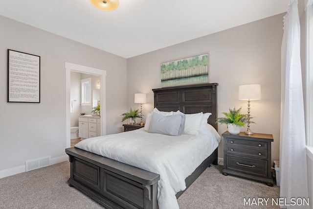 carpeted bedroom featuring visible vents, baseboards, and connected bathroom