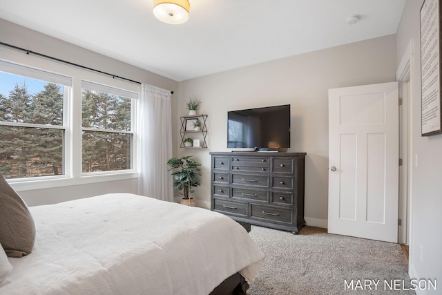 bedroom featuring light colored carpet and baseboards