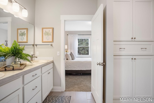 full bath with double vanity, tile patterned flooring, connected bathroom, and a sink