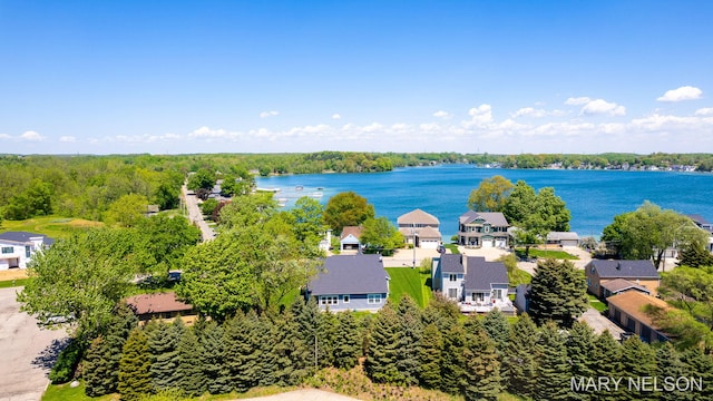 drone / aerial view featuring a residential view, a forest view, and a water view