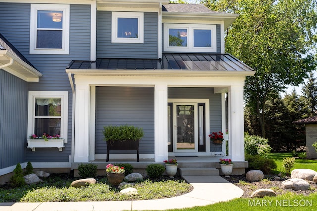 view of front facade featuring a porch, metal roof, a standing seam roof, and a shingled roof