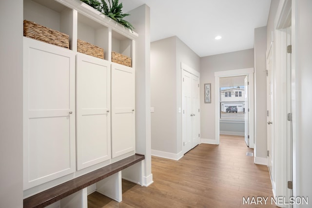 mudroom with recessed lighting, baseboards, and light wood finished floors