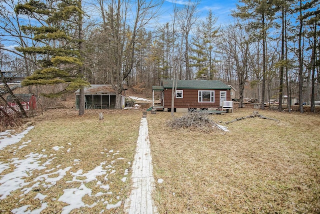 rear view of house featuring a yard and an outdoor structure