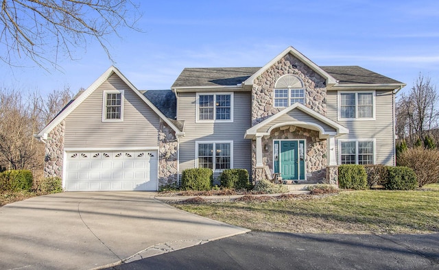 view of front of house with stone siding, driveway, a front yard, and a garage