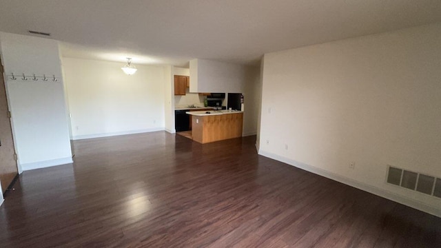 unfurnished living room featuring baseboards, visible vents, and dark wood-type flooring