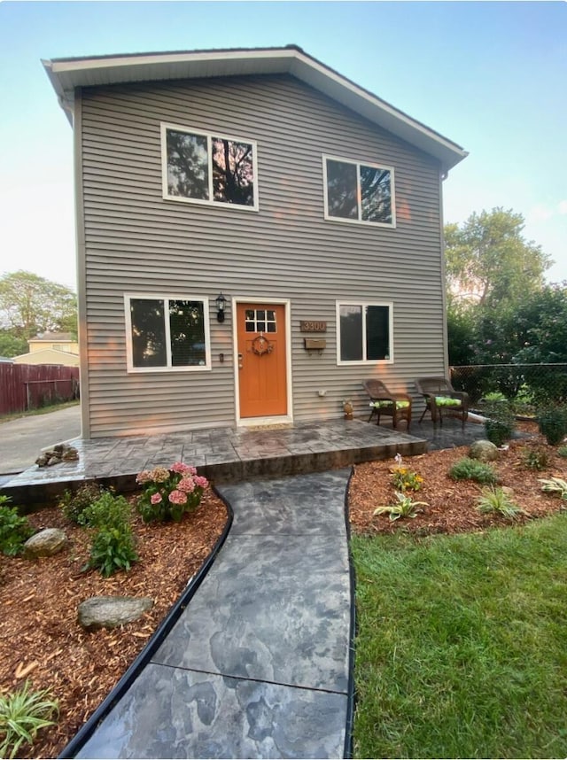 view of front facade with fence and a patio