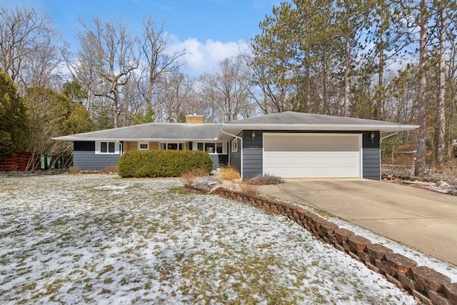 single story home with a garage, concrete driveway, and a chimney