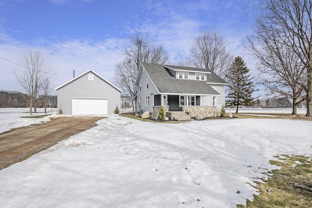 view of front of home with stone siding, a detached garage, and an outbuilding