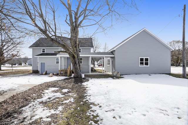 view of snow covered rear of property