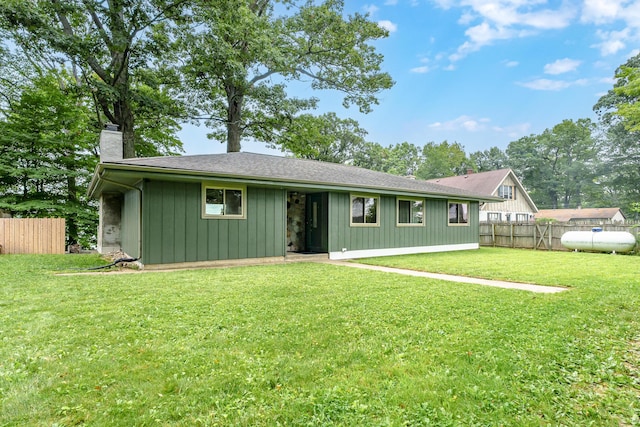 view of front of house with a front lawn, a chimney, and fence