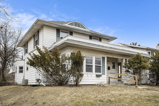 american foursquare style home featuring a shingled roof and central AC unit