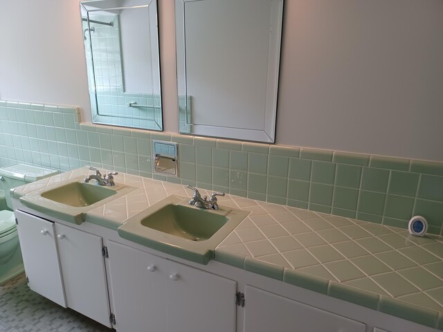 4265 Pine Tree Trl, Bloomfield Hills, MI 48302 - full bathroom with double vanity, backsplash, toilet, and a sink