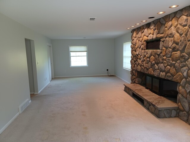 4265 Pine Tree Trl, Bloomfield Hills, MI 48302 - unfurnished living room with light carpet, visible vents, a stone fireplace, and baseboards
