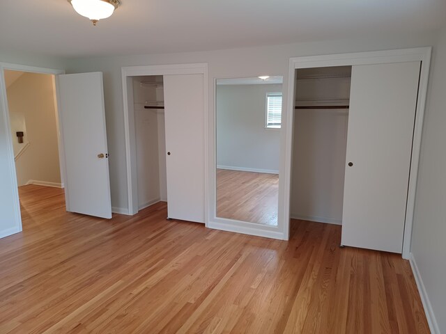 4265 Pine Tree Trl, Bloomfield Hills, MI 48302 - unfurnished bedroom featuring light wood-style floors, multiple closets, and baseboards