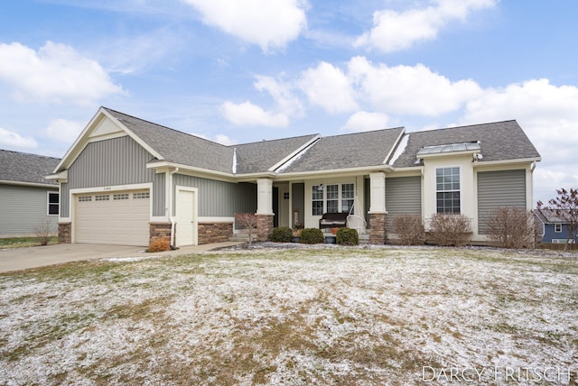 view of front of property featuring a porch, an attached garage, concrete driveway, stone siding, and roof with shingles