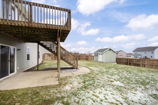 view of yard with a patio, a fenced backyard, stairway, an outbuilding, and a storage unit