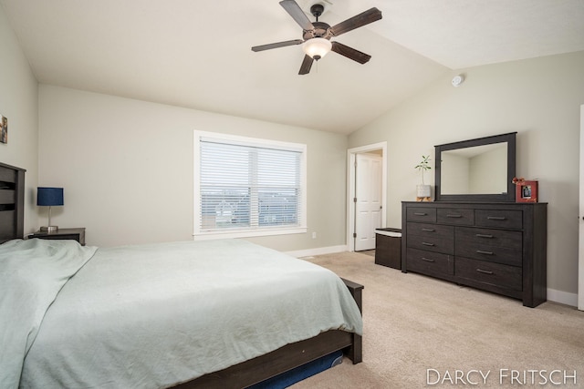 bedroom with lofted ceiling, light carpet, ceiling fan, and baseboards