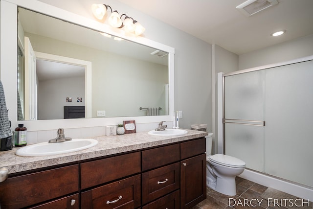 full bathroom featuring a stall shower, a sink, and toilet