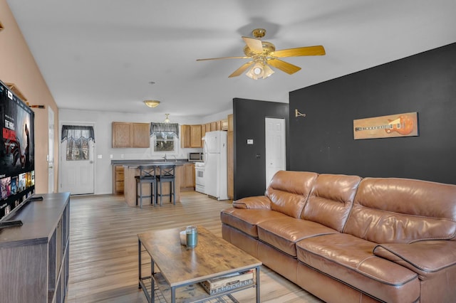 living area featuring light wood finished floors and a ceiling fan