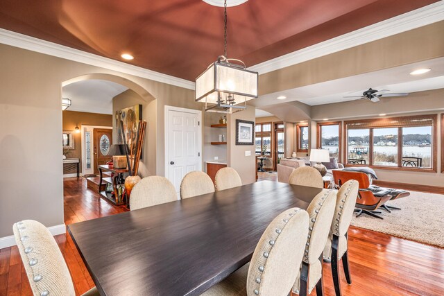 14788 Boom Rd, Spring Lake, MI 49456 - dining room featuring arched walkways, crown molding, hardwood / wood-style flooring, and baseboards