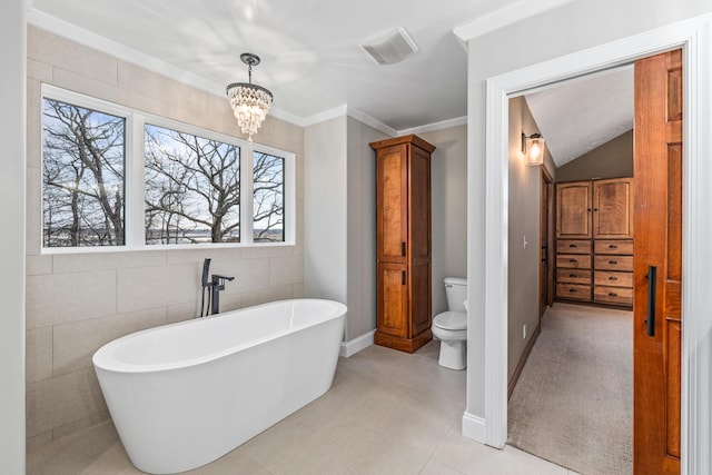 14788 Boom Rd, Spring Lake, MI 49456 - bathroom featuring toilet, a notable chandelier, visible vents, a freestanding bath, and ornamental molding
