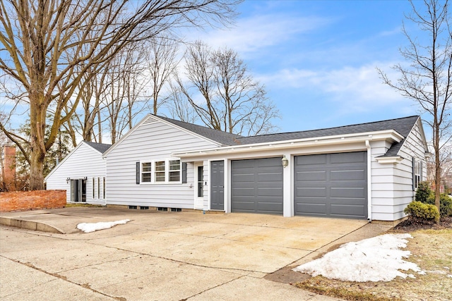 ranch-style home with concrete driveway, roof with shingles, and an attached garage