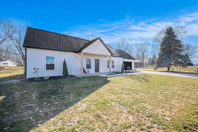 modern inspired farmhouse with concrete driveway, roof with shingles, an attached garage, a patio area, and a front yard