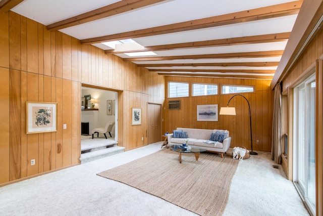 living area featuring a skylight, beam ceiling, light colored carpet, and a wall mounted AC