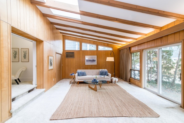 living room with carpet floors, an AC wall unit, wood walls, and vaulted ceiling with skylight