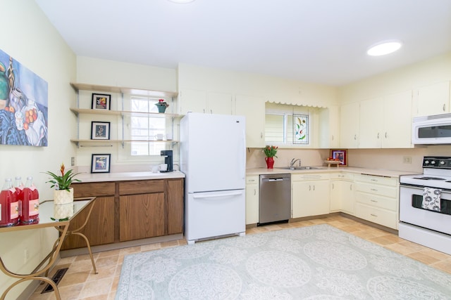 kitchen featuring light countertops, white appliances, a sink, and a healthy amount of sunlight