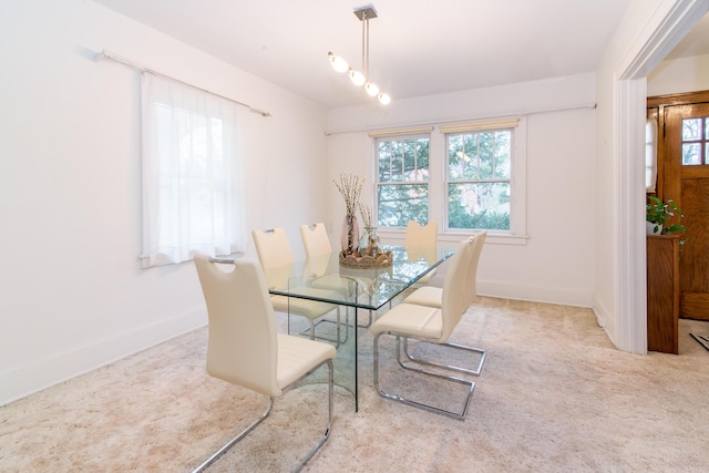 carpeted dining room with baseboards