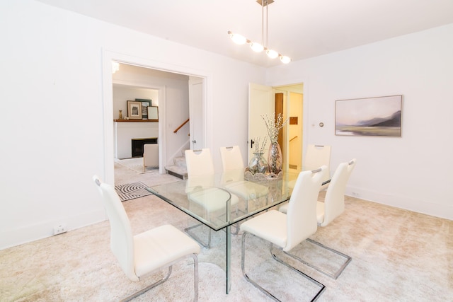 dining room featuring light colored carpet and stairs