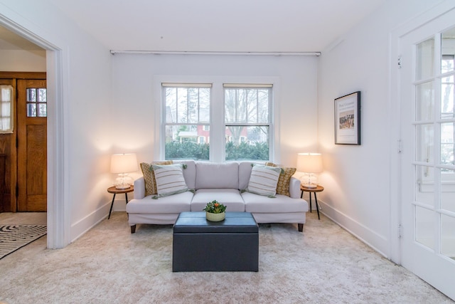 carpeted living area featuring baseboards